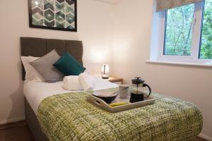 łóżko z tacą z jedzeniem na górze w obiekcie Jdb West Ham 2-Bedroom with parking w Londynie