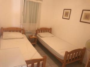 two twin beds in a room with a window at CORTADERIA B002 in Saint-Cyprien