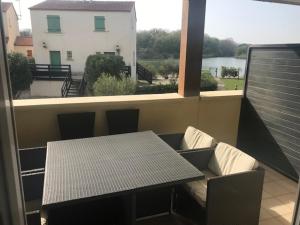 a table and bench on a balcony with a window at CORTADERIA B002 in Saint-Cyprien