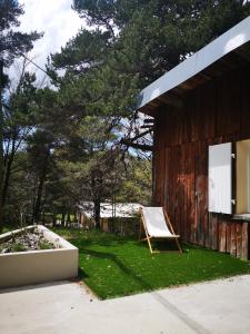 a chair sitting in the grass next to a building at Un chalet au Ventoux - Mont Serein in Mont Serein +40 photos