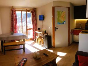 a living room with a table and a kitchen at Appartement rénové au cœur d'Arêches-Beaufort, proche pistes, balcon plein sud, piscine, pour 4 pers. - FR-1-342-167 in Arêches