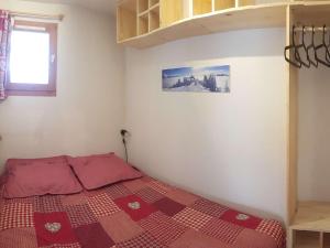 a bedroom with a bed with a red and white quilt at Appartement rénové au cœur d'Arêches-Beaufort, proche pistes, balcon plein sud, piscine, pour 4 pers. - FR-1-342-167 in Arêches