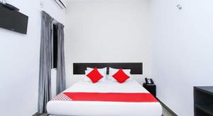 Bett mit roten Kissen in einem weißen Zimmer in der Unterkunft KINGS GATE Airport TRANSIT HOTEL in Katunayaka