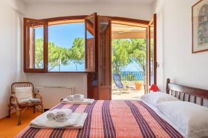 a bedroom with a bed and a large window at Casette all'Addaura by DomuSicily in Mondello