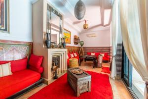 een woonkamer met een rode bank en een open haard bij Riad Espoir, Riad de charme en exclusivité dans la médina de Marrakech in Marrakesh