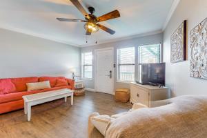 a living room with a red couch and a flat screen tv at Sea Breeze #312 in Gulf Shores