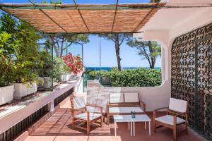 balcone con sedie, tavoli e vista sull'oceano di Casette all'Addaura by DomuSicily a Mondello