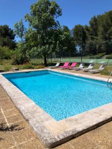 uma grande piscina com espreguiçadeiras e uma árvore em Château la Sable, chambres d'hôtes em Cucuron