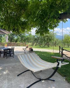 a hammock sitting under a tree in a park at B&B Fonte Vena in Norcia