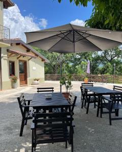 a table and chairs with a large umbrella at B&B Fonte Vena in Norcia