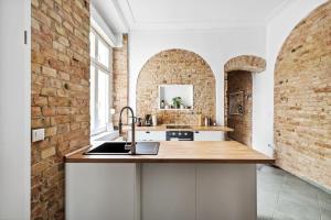 a kitchen with a sink and a brick wall at Trendy 3 room apartment in Kreuzberg in Berlin