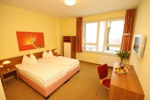 a hotel room with a bed and a table with a bowl of fruit at smartMotel in Kempten