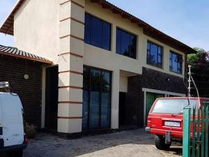 a house with a red van parked in front of it at Garden Cottage in Alberton