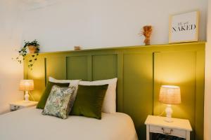 - une chambre avec un lit doté d'une tête de lit verte dans l'établissement Villa Rafa, à Costa Nova