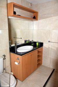 a bathroom with a sink and a toilet at Apartamento moderno com vista para o mar in Sal Rei