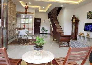 - un salon avec une table et des chaises ainsi qu'un escalier dans l'établissement JOBO Guest House 4BR, à Karangploso
