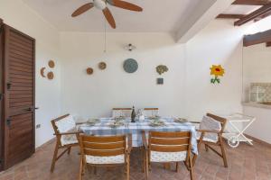 ein Esszimmer mit einem Tisch mit Stühlen und einem Deckenventilator in der Unterkunft Villino Pepe Rosa by BarbarHouse in Torre dell'Orso + 23 Fotos