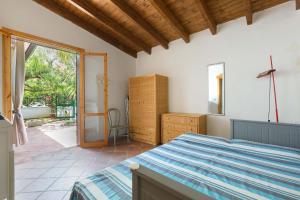 ein Schlafzimmer mit einem Bett und einer Glasschiebetür in der Unterkunft Villino Pepe Rosa by BarbarHouse in Torre dell'Orso