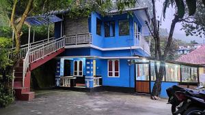 una casa azul con una escalera delante de ella en Munnar happy holidayss en Munnar