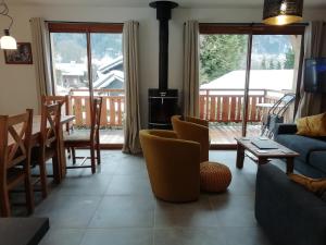 uma sala de estar com um sofá e cadeiras e uma lareira em Chalet Rivendell, Morzine sleeps 10 with garage em Morzine