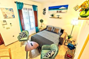 a bedroom with a bed and chairs in it at Ribera De Luxe Central Apartment with Ascensor in El Puerto de Santa María