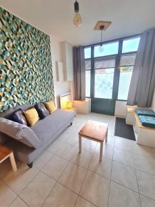 ein Wohnzimmer mit Couch und Tisch in der Unterkunft Appartement Samuel centre ville Les Herbiers, 10 min du Puy du Fou in Les Herbiers