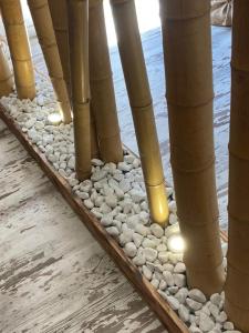 a bamboo floor with rocks and the water at La Casita in Ventas de Zafarraya