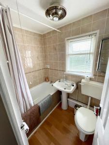 a bathroom with a tub and a sink and a toilet at Sundowner Chalet Great For Families in Great Yarmouth
