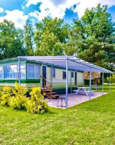 une maison avec un auvent et une terrasse en gazon dans l'établissement Uroczysko Warta, à Uniejów