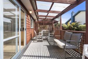 a screened porch with chairs and a table at Budget By The Bay in Apollo Bay