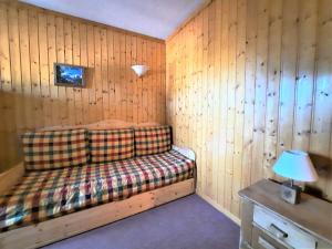 a room with a couch in a wooden wall at Charmant studio cabine 4 pers. aux Bruyères, pied des pistes, animaux permis - FR-1-452-7 in Les Menuires
