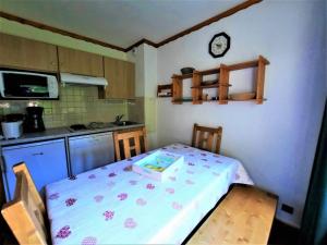 a small kitchen with a table with a box on it at Charmant studio cabine 4 pers. aux Bruyères, pied des pistes, animaux permis - FR-1-452-7 in Les Menuires