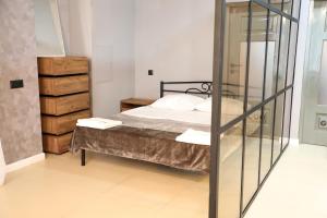 1 dormitorio con 1 cama y puerta de cristal en Good Loft en Gudauta
