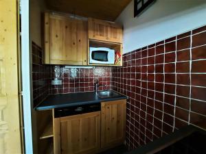 uma pequena cozinha com um lavatório e um micro-ondas em Appartement Les Menuires, 2 pièces, 5 personnes - FR-1-452-93 em Les Menuires