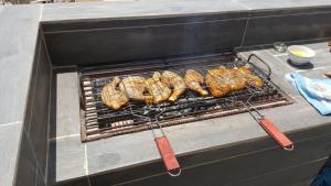 a grill with chicken and other food on it at Apartamento moderno com vista para o mar in Sal Rei