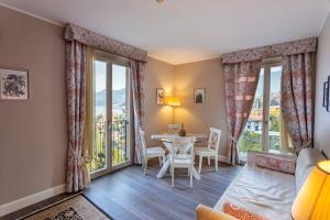 a living room with a table and chairs and large windows at Borgo Le Terrazze in Bellagio