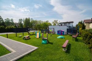 park z placem zabaw z ławkami na trawie w obiekcie Domki GENAKER w Jastrzębiej Górze