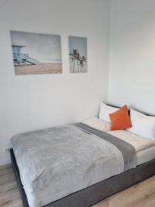 1 cama en una habitación blanca con 2 cuadros en la pared en JBHotels Apartament Comfort Hanza Tower, en Szczecin