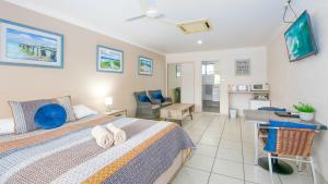 a bedroom with a bed with towels on it at Yamba Twin Pines Motel in Yamba