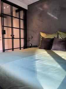 a bedroom with a large bed with blue sheets and pillows at NY style entire apartment w/private cozy terrace in Harrislee