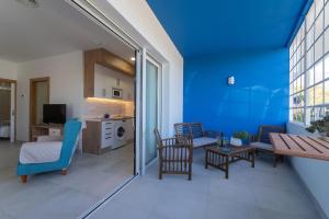 sala de estar con paredes azules, mesa y sillas en Apartamentos turísticos De La Abuela Carmen, en Estepona