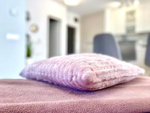a pink pillow sitting on top of a pink blanket at Forest View Apartment in Timişoara +45 photos