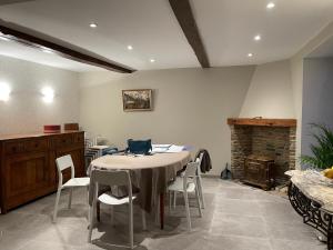 a dining room with a table and chairs and a fireplace at Gîte Les Pimprenelles Beauraing in Beauraing