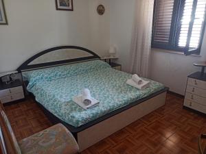 Apartment Dunka في مارتينيسكا: غرفة نوم عليها سرير وفوط