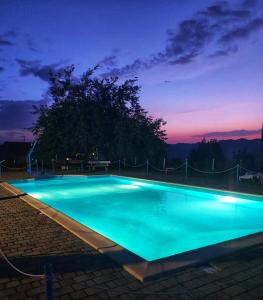 a swimming pool lit up at night at Casale Trusella in Ponti