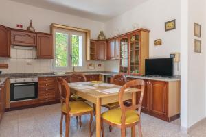 uma cozinha com uma mesa de madeira e cadeiras em Villa Alexandra em Belvedere
