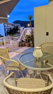 a glass table and chairs on a patio with a view at Emanuela SunnySide in Kavála