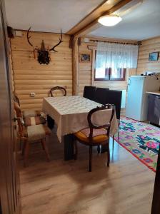 a kitchen and dining room with a table and chairs at Cabana Dochita in Ceahlău