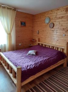 a bedroom with a bed in a wooden room at Cabana Dochita in Ceahlău