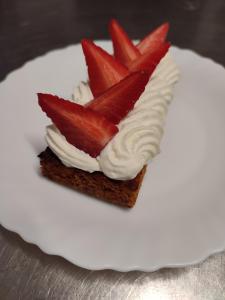 a dessert with whipped cream and strawberries on a plate at L'HotenTyka in Saint-Senoch